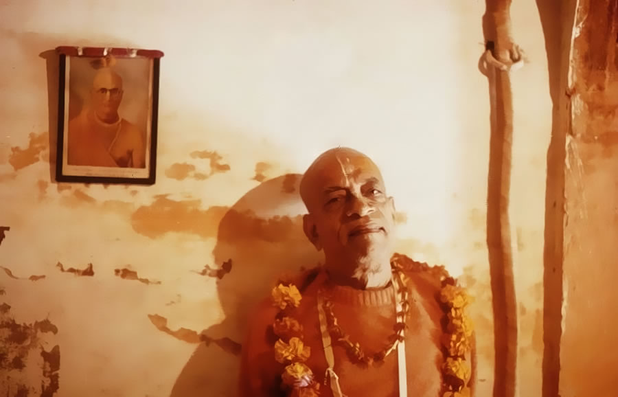 Srila Prabhupada standing beside a photo of his guru maharaja