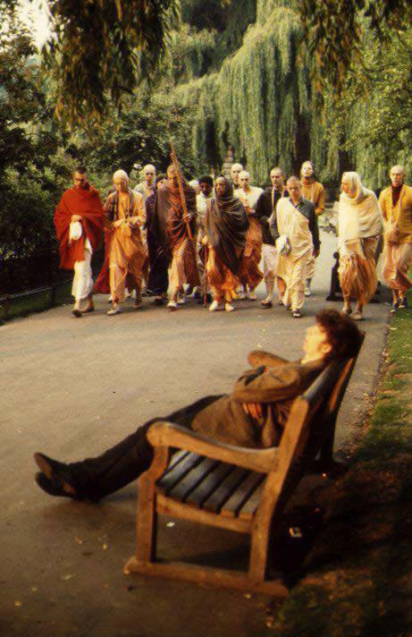 While others are being enlightened a man sleeps in ignorance as Srila Prabhupada walks by.